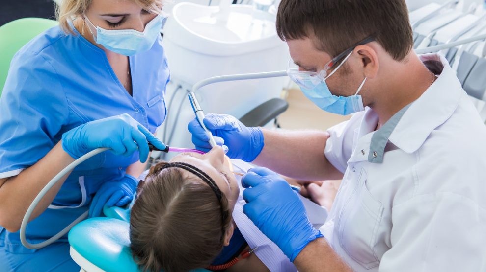 Dentiste avec son assistant soignant un patient