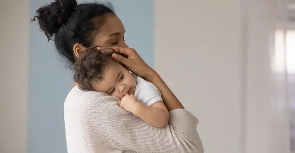 Auxiliaire de puériculture tenant un bébé dans ses bras