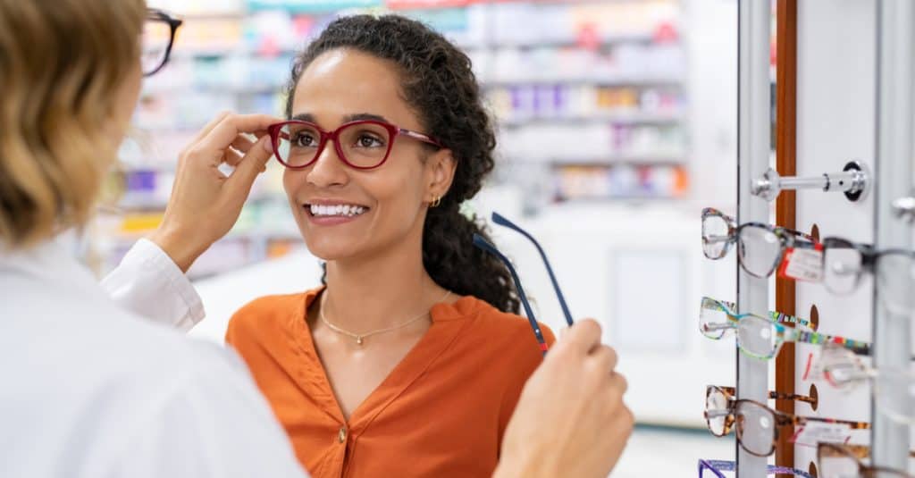 Opticien faisant essayer des lunettes à une cliente