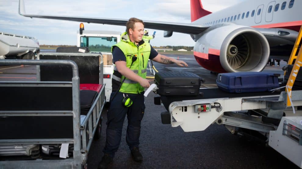 Agent de piste dépose les bagages dans un avion