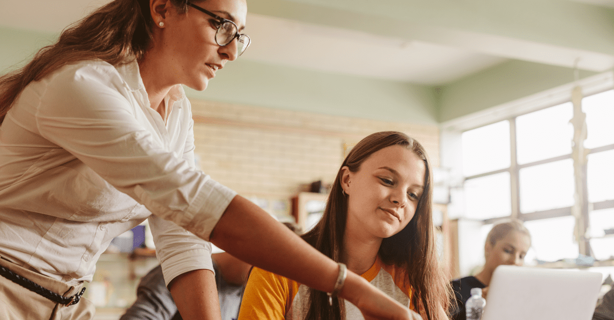 Assistante d'éducation aidant une élève sur un exercice