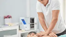 Kiné exercant des pressions sur le dos d'un homme
