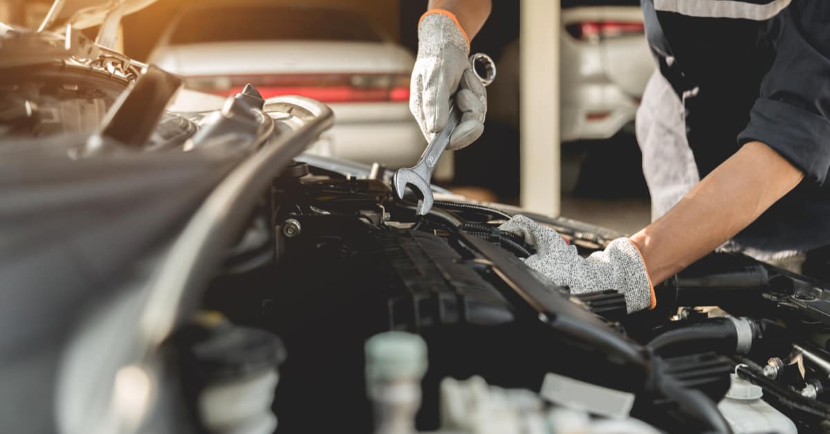 Mécanicien effectuant la réparation d'un moteur de voiture