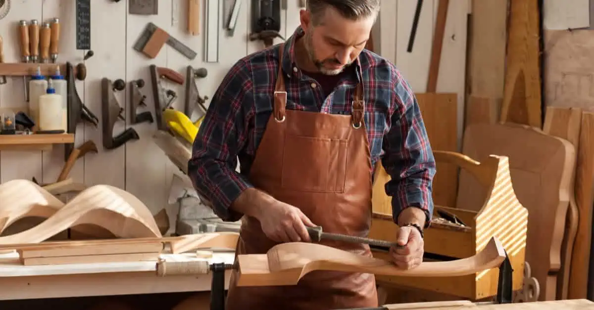 Ebeniste travaille sur un pied de chaise dans son atelier