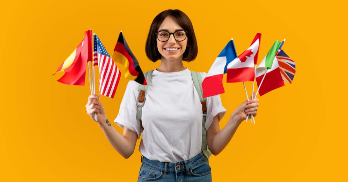 Jeune femme tenant des drapeaux de différents Pays dans ses mains