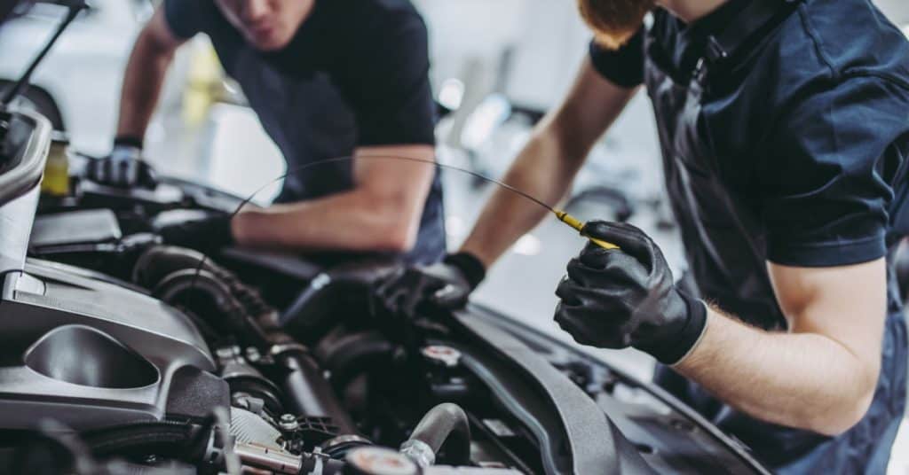 Mécaniciens qui réalisent l'entretien d'une voiture