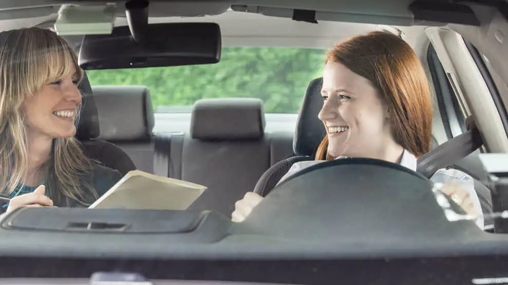 Monitrice d'auto-école donne un cours à une élève