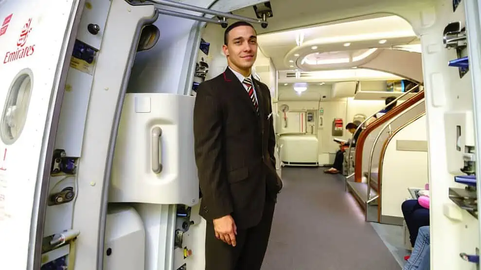 Steward à l'entrée d'un avion de la compagnie Emirates